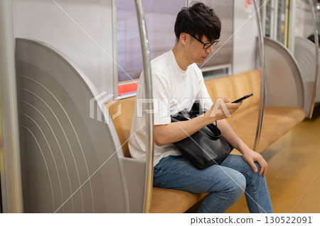 A man looking at his smartphone on the train 130522091