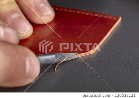The process of making leather goods. The hands of the master work with a leather product. 130522121