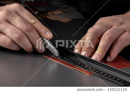 The process of making leather goods. The hands of the master work with a leather product. The process of making leather goods. The hands of the master work with a leather product. 130522129
