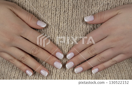 Classic white manicure on natural wool background. Classic white manicure on natural wool background. 130522152