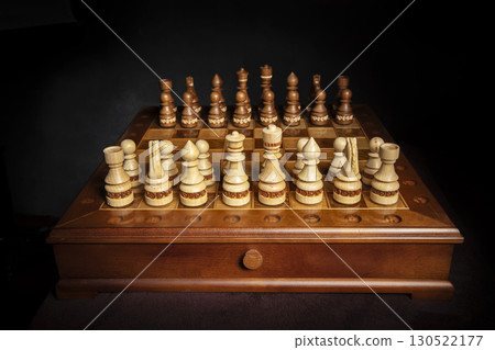 Chess pieces of wood on a beautiful chessboard. A puzzle game with tricky combinations that requires planning and thinking. Chess pieces of wood on a beautiful chessboard. A puzzle game with tricky combinations that requires planning and thinking. 130522177