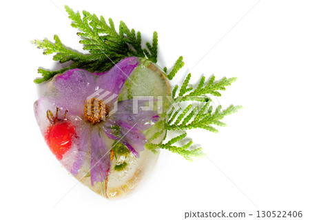 Summer flowers in the shape of an ice heart. Frozen flowers and plants. 130522406