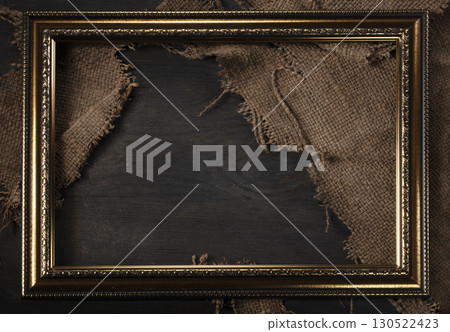 In a beautiful frame, a coarse weave fabric on a wooden background. Background for the inscription. 130522423