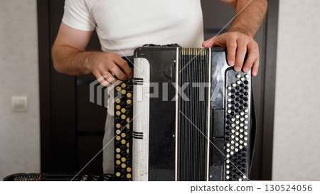 Technician repairing accordion with tools on table 130524056
