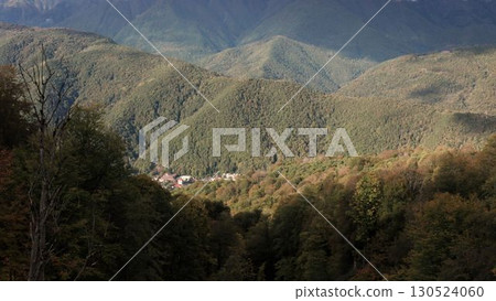 Aerial view of one of the longest pedestrian suspension bridge, surrounded by mountains and river valley. Mountains in Sochi. Taken by drone. 130524060