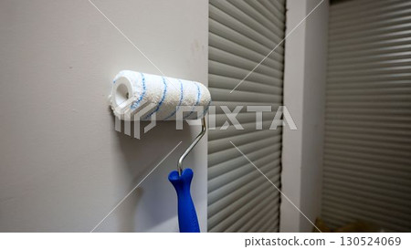 Clean paint roller leaning against wall near garage door Clean paint roller leaning against wall near garage door 130524069