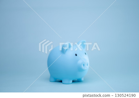 A hand is dropping coins into a piggy bank. The concept of saving and investing. A hand is dropping coins into a piggy bank. The concept of saving and investing. 130524190