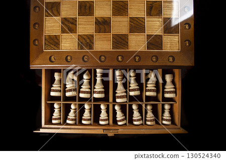 White chess pieces are stacked in a box. A puzzle game with tricky combinations that requires planning and thinking. White chess pieces are stacked in a box. A puzzle game with tricky combinations that requires planning and thinking. 130524340