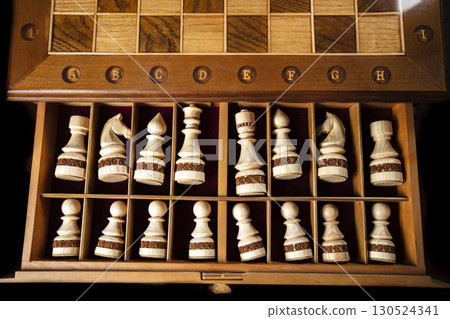 White chess pieces are stacked in a box. A puzzle game with tricky combinations that requires planning and thinking. White chess pieces are stacked in a box. A puzzle game with tricky combinations that requires planning and thinking. 130524341