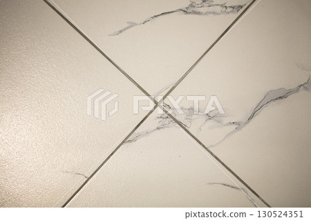 Above photographed part of light ceramic tiles with gray veins. 130524351
