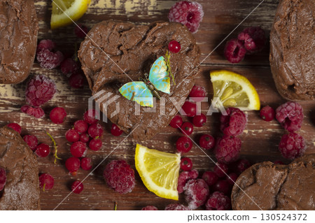A beautiful chocolate dessert decorated with dimona wedges, berries and a vintage butterfly. Sweet food. 130524372