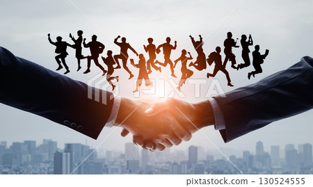 Silhouette of a business person shaking hands with various people jumping against a city background 130524555