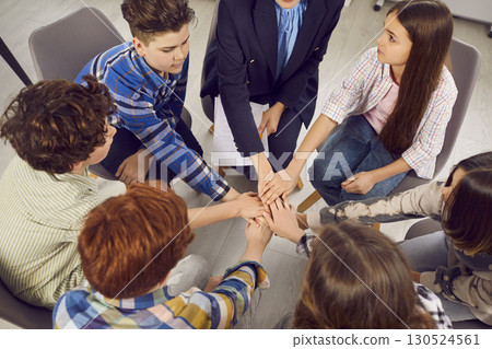 Group of school kids together with teacher learning what teamwork and support are 130524561