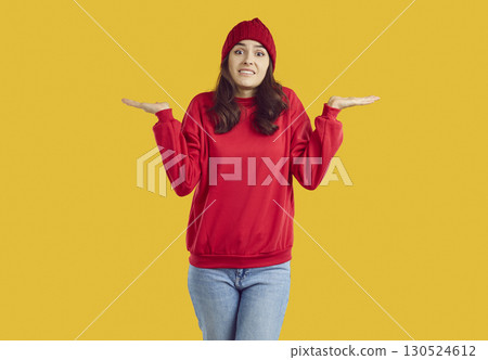 Doubtful young woman shrugging shoulder spreading her arms to sides Doubtful young woman shrugging shoulder spreading her arms to sides 130524612