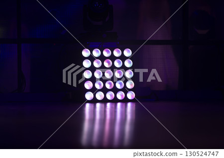 A stage lamp stands on the floor with a reflection. A stage lamp stands on the floor with a reflection. 130524747