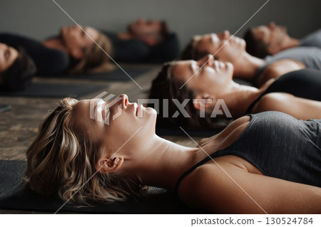 Group of young sporty people practicing yoga lesson with instructor in gym, , doing Savasana, generated AI 130524784