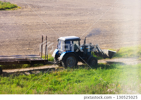 A tractor is currently working diligently in an agricultural field A tractor is currently working diligently in an agricultural field 130525025