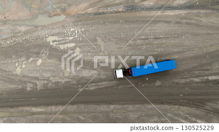 Aerial View semi truck on dirt road, Semi truck with  trailer on dirt road countryside, Top view of semi truck cargo driving on dirt road. 130525229