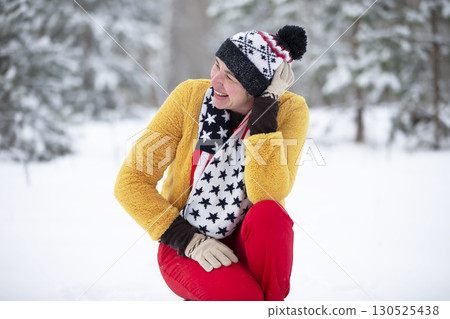 Happy middle-aged woman in the winter forest on a walk. 130525438