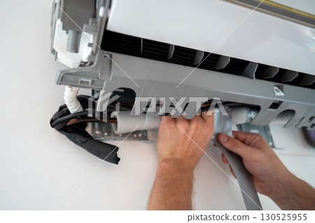 Damaged insulation on copper pipe of indoor air conditioner unit causing water leakage down wall 130525955