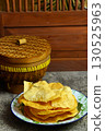 Golden and crispy opak or Indonesian Cassava Crackers on a vintage enamel plate. A popular savory snack with a crunchy texture. 130525963