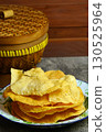 Golden and crispy opak or Indonesian Cassava Crackers on a vintage enamel plate. A popular savory snack with a crunchy texture. 130525964