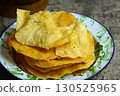 Golden and crispy opak or Indonesian Cassava Crackers on a vintage enamel plate. A popular savory snack with a crunchy texture. 130525965