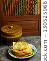 Golden and crispy opak or Indonesian Cassava Crackers on a vintage enamel plate. A popular savory snack with a crunchy texture. 130525966
