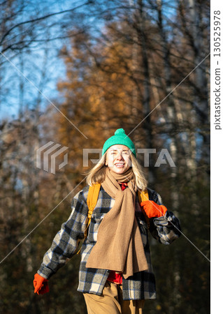 Happy backpacker woman with wide cheerful smile walking in autumn forest at nice sunny weather. Happy backpacker woman with wide cheerful smile walking in autumn forest at nice sunny weather. 130525978