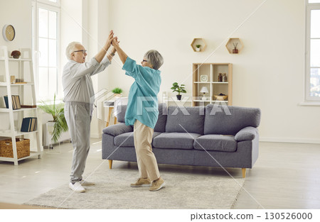 Happy senior family couple wife and husband dancing in the living room at home. 130526000