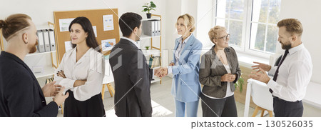Diverse male and female business professionals socialize and network in modern office. 130526035