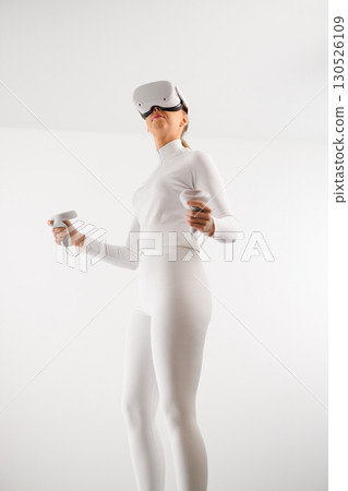 Female wearing VR glasses practicing martial arts Female wearing VR glasses practicing martial arts 130526109
