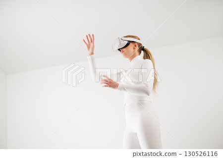 Woman in VR glasses shopping virtually in studio 130526116