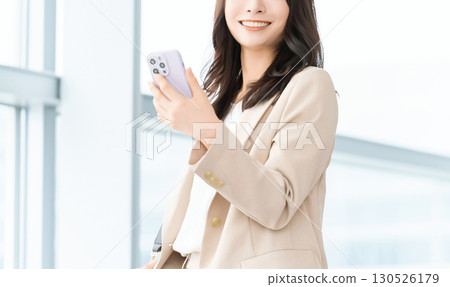 Smiling woman/businesswoman holding a smartphone Smiling woman/businesswoman holding a smartphone 130526179