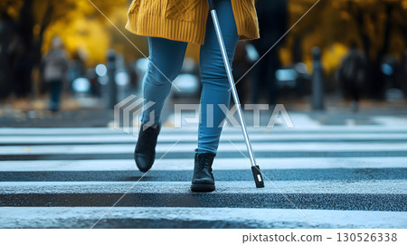 A visually impaired person confidently walking in the city with a smart AI cane. Ideal for inclusive tech, accessibility, and social equality themes. 130526338