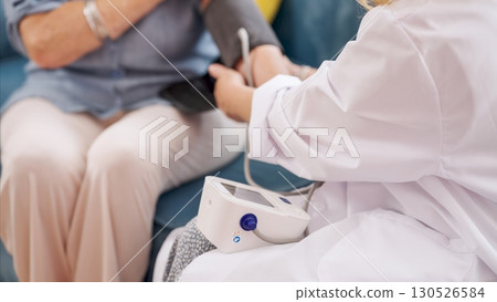Doctor measuring blood pressure of senior woman at home 130526584
