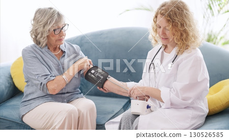 Healthcare professional checking blood pressure of senior woman Healthcare professional checking blood pressure of senior woman 130526585