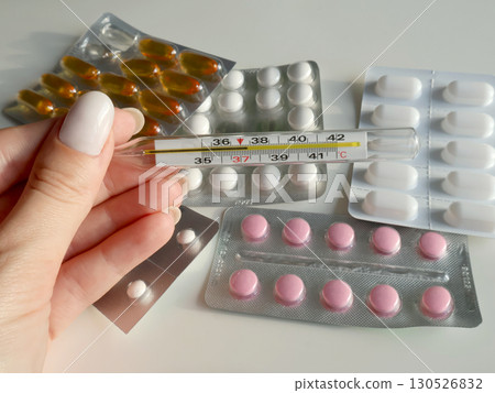 Medical Supplies Including Pills and Thermometer in Female Hand Medical Supplies Including Pills and Thermometer in Female Hand 130526832