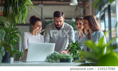 Group of professionals working together in an office, collaborating around a laptop during a team meeting. Great for teamwork, startup, and corporate use. 130527090