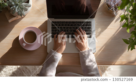 Freelancer working remotely from home with a relaxed and productive setup. Ideal for blogs, tech services, and work-from-home promotions. 130527169