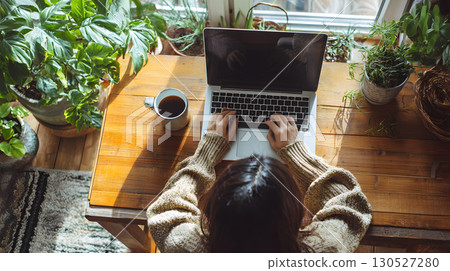 Freelancer working remotely from home with a relaxed and productive setup top view. Ideal for blogs, tech services, and work-from-home promotions. 130527280