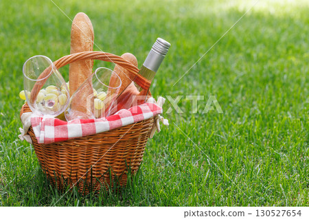 Picnic basket with wine, grapes, and baguette 130527654