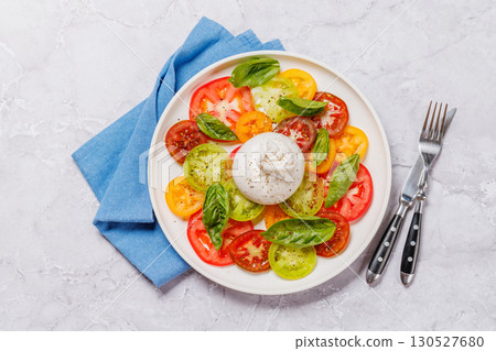 Fresh burrata served on slices of colorful tomatoes 130527680