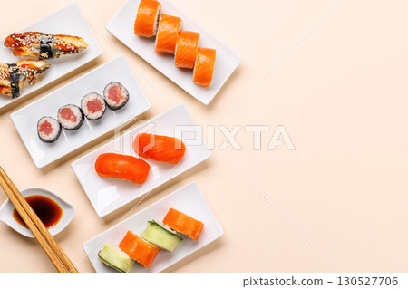 Wooden chopsticks elegantly placed beside a small bowl of soy sauce on a clean white background 130527706