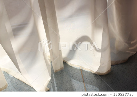 Sheer white curtains with sunlight and shadows on floor Sheer white curtains with sunlight and shadows on floor 130527753