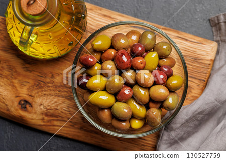An assortment of various olives presented in a bowl, showcasing different colors, textures, and flavors An assortment of various olives presented in a bowl, showcasing different colors, textures, and flavors 130527759