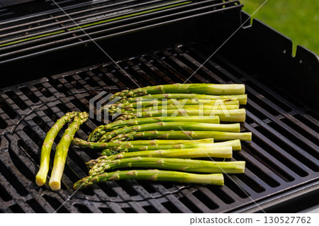 Fresh asparagus spears sizzling on a hot grill Fresh asparagus spears sizzling on a hot grill 130527762
