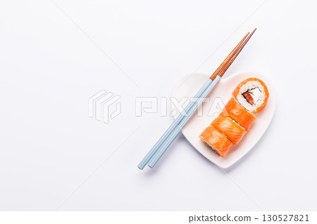 A heart-shaped plate filled with delicious sushi, accompanied by chopsticks 130527821
