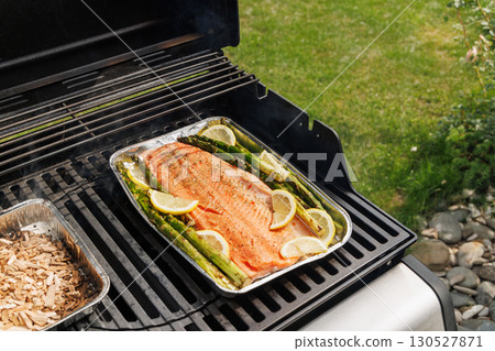 Grilled salmon fillets and asparagus sizzling on a barbecue grill Grilled salmon fillets and asparagus sizzling on a barbecue grill 130527871