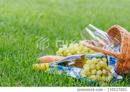 Picnic basket with wine, grapes, and baguette 130527881